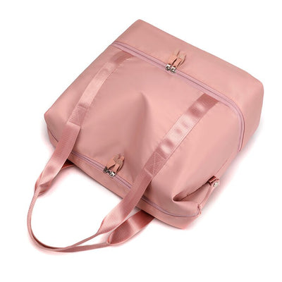 Sac de voyage rose en tissu imperméable avec fermeture éclair, poignées robustes et design élégant. Accessoire idéal pour voyages et week-ends.