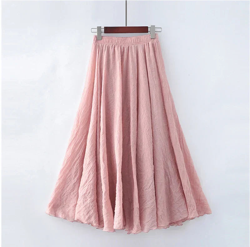 Jupe longue rose en mousseline, fluide et élégante, suspendue sur un cintre. Mode féminine, vêtement d'été, style bohème chic.