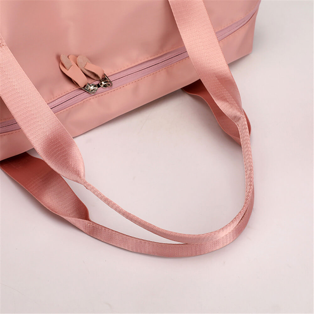 Sac de sport rose en tissu imperméable avec fermeture éclair et longues anses. Idéal pour le fitness, le voyage ou le quotidien.