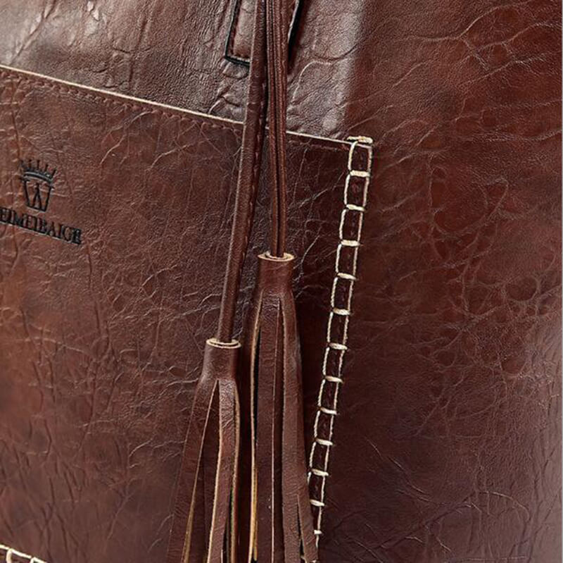 Sac en cuir marron avec coutures blanches contrastantes et franges décoratives. Accessoire mode élégant et tendance pour femmes.
