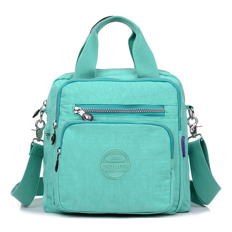 Sac à main vert menthe en toile avec bandoulière amovible, poches zippées et logo. Idéal pour femme, mode, accessoires tendance.