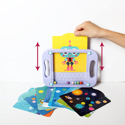 Jeu éducatif pour enfants avec cartes colorées et tableau magnétique, main ajustant une carte de robot, idéal pour apprentissage et créativité.