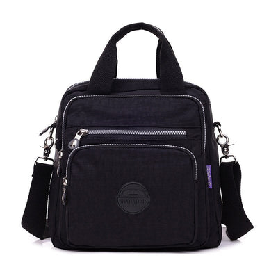 Sac à bandoulière noir en nylon avec plusieurs poches zippées, poignées robustes et bandoulière ajustable. Design pratique et moderne pour homme.