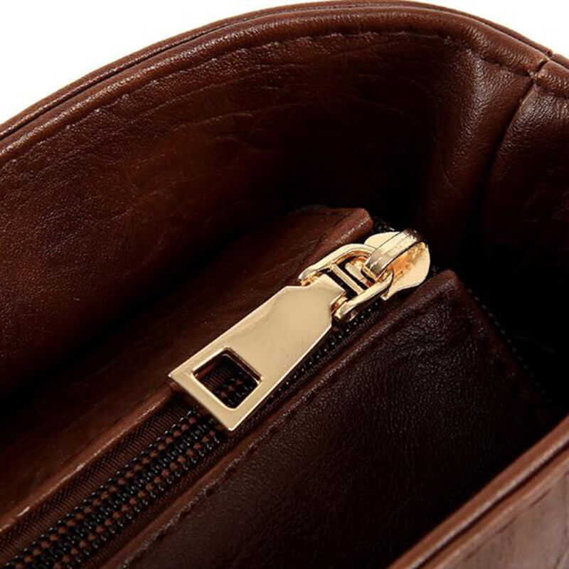 Gros plan d'un sac à main en cuir marron avec fermeture éclair dorée, design élégant et moderne, accessoire de mode pour femme.