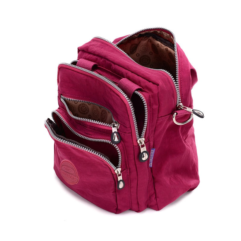 Sac à dos rouge bordeaux avec plusieurs poches zippées, design compact et moderne, idéal pour le voyage et l'école. Accessoire mode pratique.