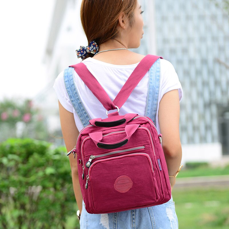 Femme portant un sac à dos rose en plein air, style décontracté, mode féminine, sac pratique pour voyage ou quotidien, tendance et fonctionnel.