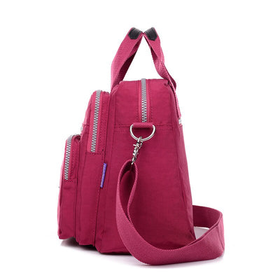 Sac à bandoulière rose pour femme, design moderne avec multiples compartiments zippés, idéal pour le quotidien et le voyage. Accessoire mode tendance.