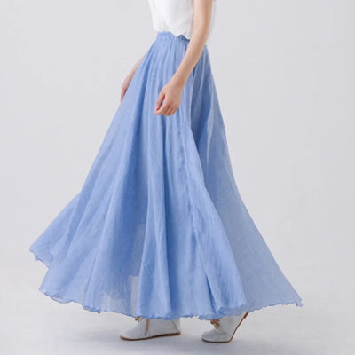 Jupe longue bleue fluide en mousseline, portée avec un haut blanc, style élégant et décontracté, mode féminine printemps-été.
