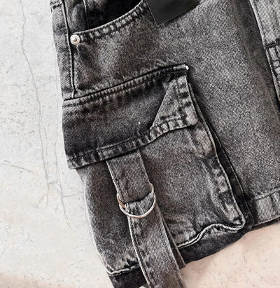 Jeans gris délavé avec poche avant et boucle métallique, style décontracté. Tissu denim texturé, tendance mode urbaine.