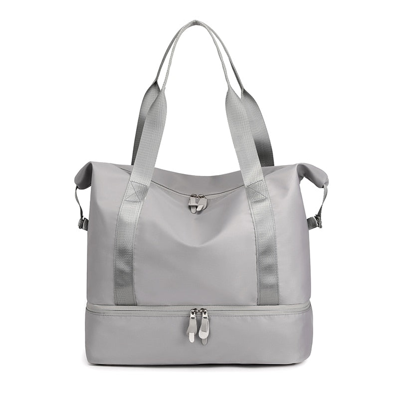 Sac de sport gris élégant avec compartiment inférieur zippé, poignées robustes et design moderne. Idéal pour fitness, voyage, rangement.
