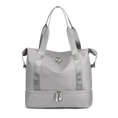 Sac de sport gris élégant avec compartiment inférieur zippé, poignées robustes et design moderne. Idéal pour fitness, voyage, rangement.