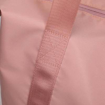 Sac à main rose en tissu avec sangle robuste et couture renforcée, design élégant et moderne, accessoire de mode féminin tendance.