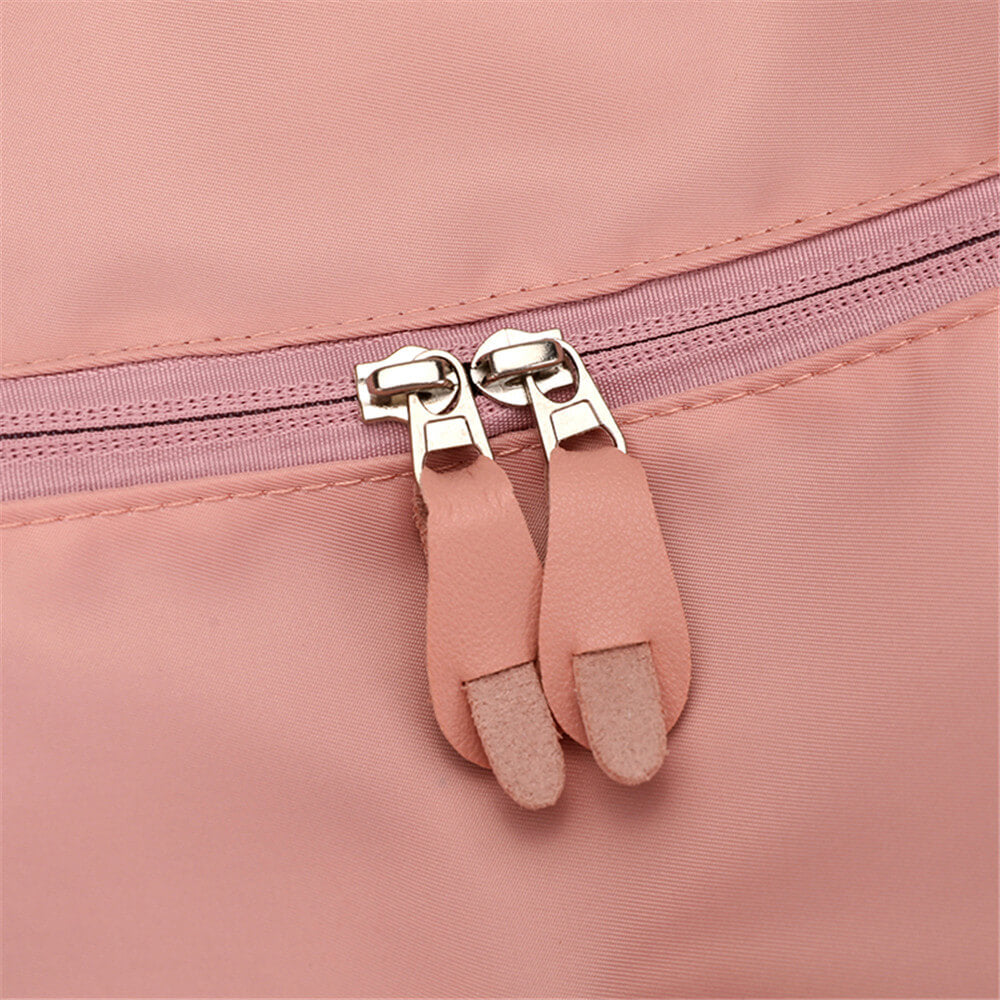 Fermeture éclair rose avec double tirette en cuir sur sac à dos. Accessoire mode, design élégant, tendance féminine, sac pratique.