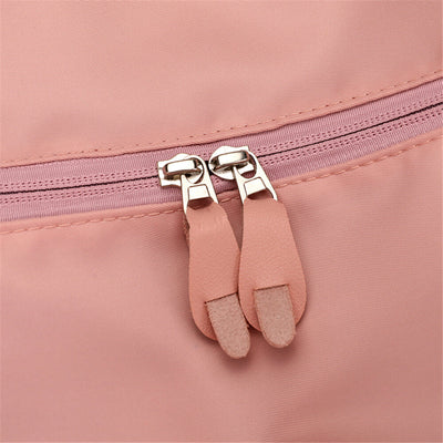 Fermeture éclair rose avec double tirette en cuir sur sac à dos. Accessoire mode, design élégant, tendance féminine, sac pratique.