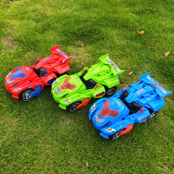 Trois voitures jouets colorées, rouge, verte et bleue, sur l'herbe. Voitures miniatures de course pour enfants, jouets extérieurs populaires.
