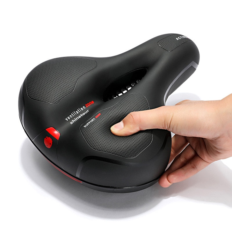 Selle de vélo ergonomique noire avec zone de ventilation, design antidérapant, amortisseur intégré, main ajustant le confort. Accessoire cyclisme.