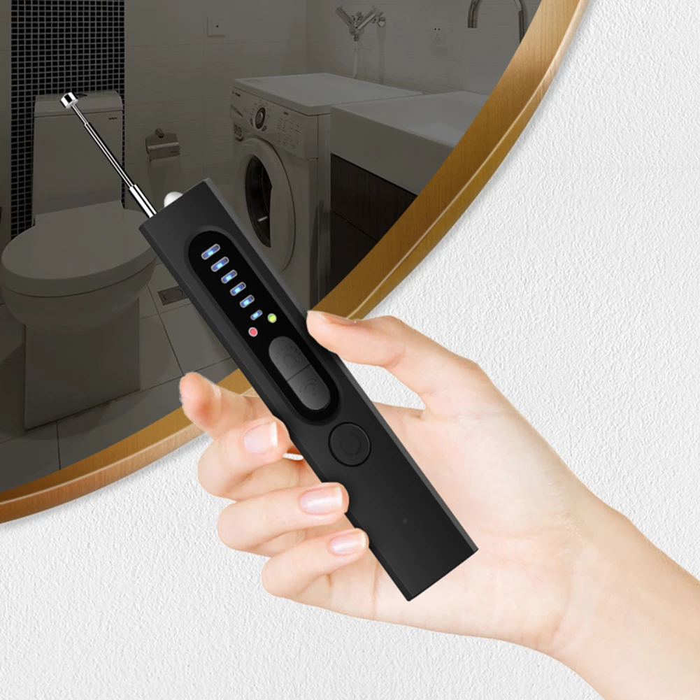 Main dans une salle de bain tenant un briquet électrique noir rechargeable, affichant des indicateurs LED. Toilettes et machine à laver en arrière-plan.