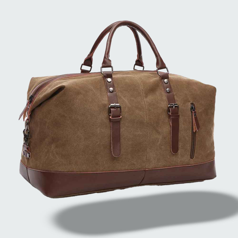 Sac de voyage en toile marron avec poignées en cuir, fermeture éclair robuste et poches extérieures. Accessoire élégant pour voyages et week-ends.