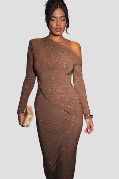 Femme portant une robe marron asymétrique scintillante, tenant une pochette dorée. Mode élégante, tenue de soirée chic, style glamour.