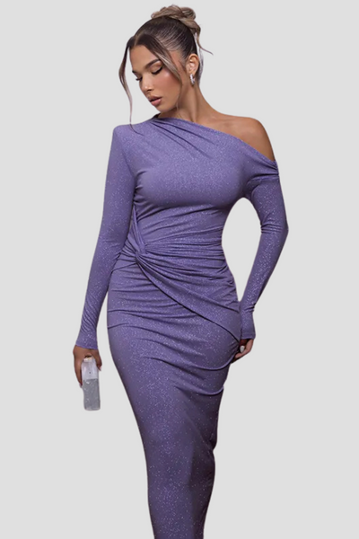 Robe longue violette à paillettes, manches longues, épaule dénudée, femme tenant un petit sac transparent. Mode élégante et tendance soirée.