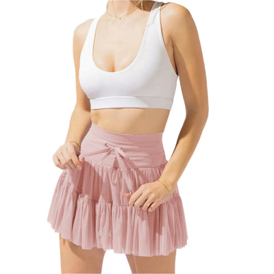 Femme en jupe rose plissée et top blanc, mode estivale élégante, tenue décontractée chic, style tendance pour femmes, vêtements légers.