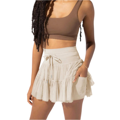 Femme portant un haut marron et une jupe beige à volants, mode estivale, style décontracté, tenue tendance, vêtements légers pour l'été.