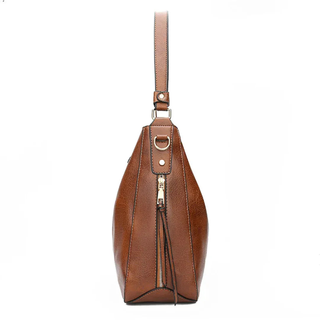 Sac à main en cuir marron avec bandoulière, fermeture éclair dorée et design élégant. Accessoire de mode pour femme, style chic et moderne.