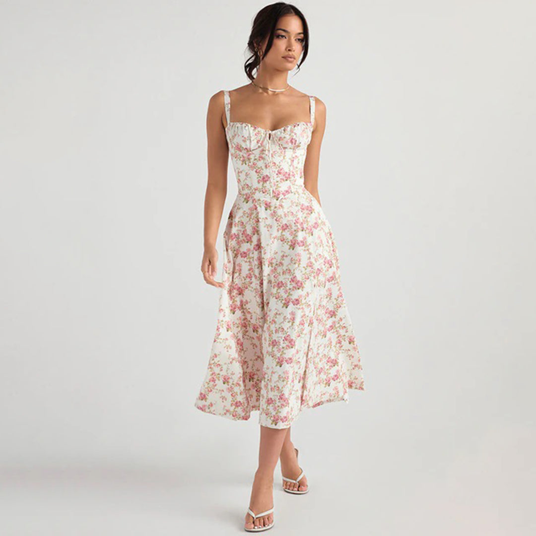 Robe longue à fleurs roses portée par une femme, style élégant et estival, fond blanc, mode féminine tendance, sandales blanches.