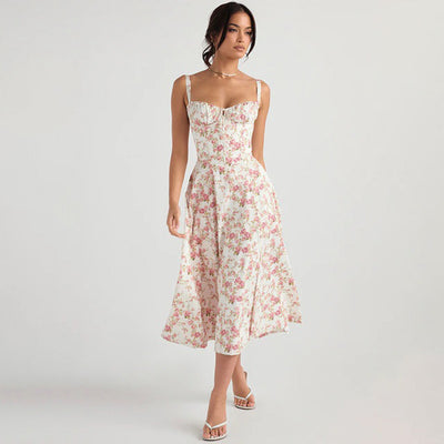 Robe longue à fleurs roses portée par une femme, style élégant et estival, fond blanc, mode féminine tendance, sandales blanches.