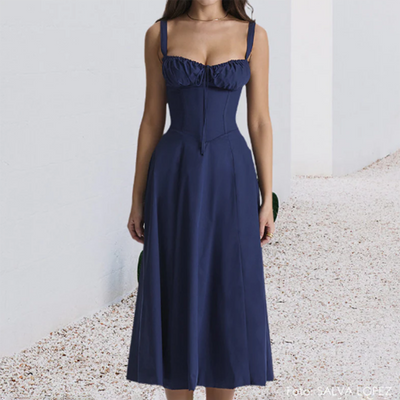 Robe bleue élégante sans manches, coupe ajustée, longueur mi-mollet, portée par une femme. Mode féminine, style chic et moderne.