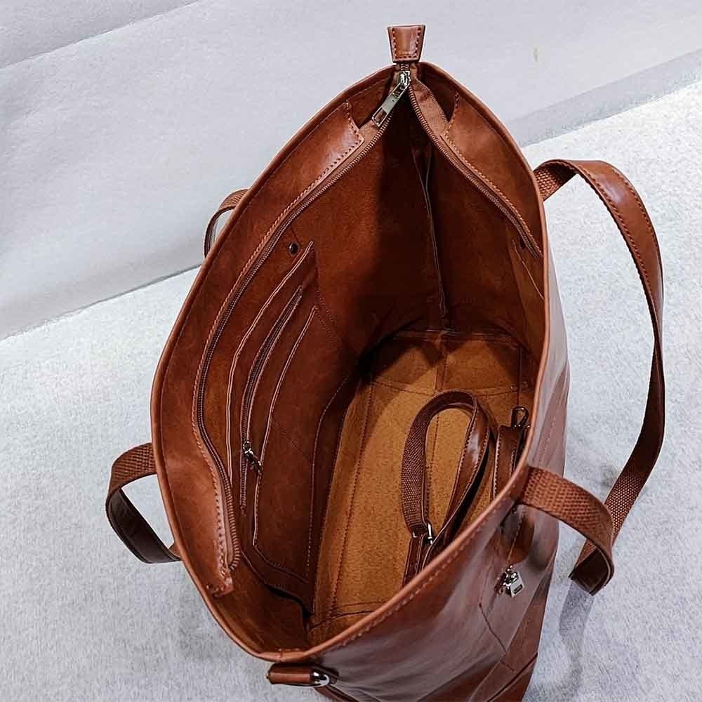 Sac à main en cuir marron ouvert, intérieur spacieux avec poches zippées et compartiments. Accessoire mode élégant et pratique pour femme.