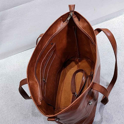 Sac à main en cuir marron ouvert, intérieur spacieux avec poches zippées et compartiments. Accessoire mode élégant et pratique pour femme.
