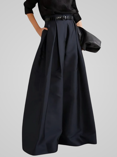 Jupe longue noire élégante avec plis, ceinture assortie et pochette noire, tenue chic et moderne pour femme, mode automne-hiver.