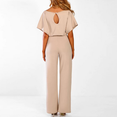 Combinaison élégante beige pour femme vue de dos, manches courtes, coupe ample, tissu fluide, idéale pour une tenue chic et moderne.