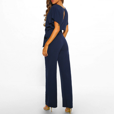 Combinaison élégante bleu marine pour femme, manches courtes, ceinture à nouer, vue de dos, idéale pour soirée ou événement formel.