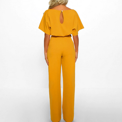 Combinaison jaune élégante pour femme, manches courtes, dos ouvert, coupe ample, mode tendance, tenue chic, style moderne, fond blanc.