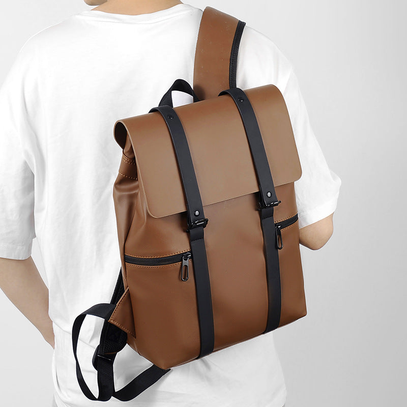 Sac à dos en cuir marron élégant avec bretelles noires, porté par une personne en t-shirt blanc. Design moderne, idéal pour le voyage et le quotidien.