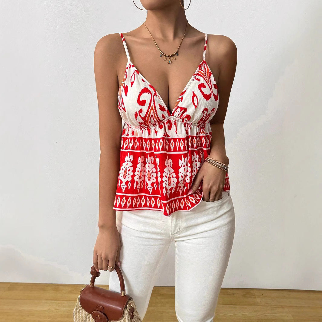 Femme portant un haut rouge et blanc à motifs ethniques, pantalon blanc, tenant un sac à main marron. Mode estivale, style décontracté chic.