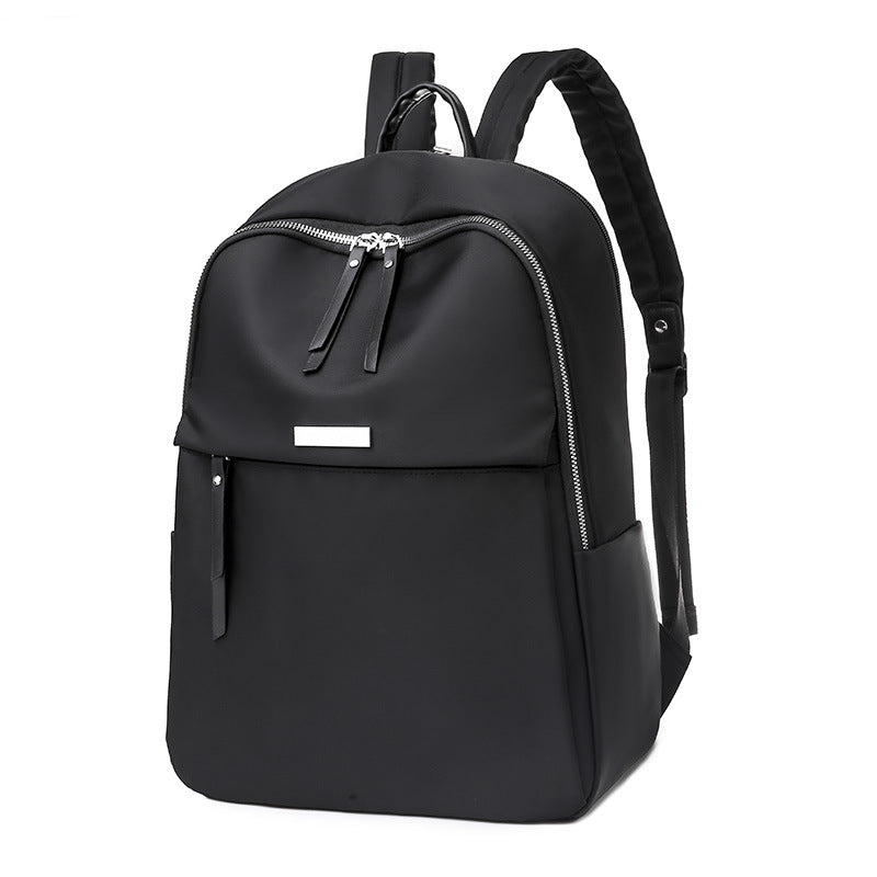 Sac à dos noir élégant avec fermetures éclair argentées, poches latérales et bretelles ajustables. Idéal pour le voyage et l'école.