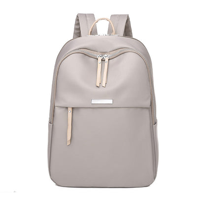 Sac à dos gris clair élégant avec fermeture éclair, design moderne et minimaliste, idéal pour l'école ou le travail. Accessoire mode pratique.