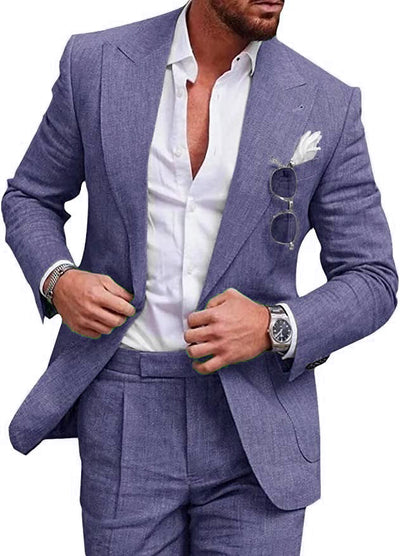 Homme en costume bleu élégant, chemise blanche ouverte, lunettes de soleil accrochées, montre-bracelet argentée, mouchoir blanc dans la poche.