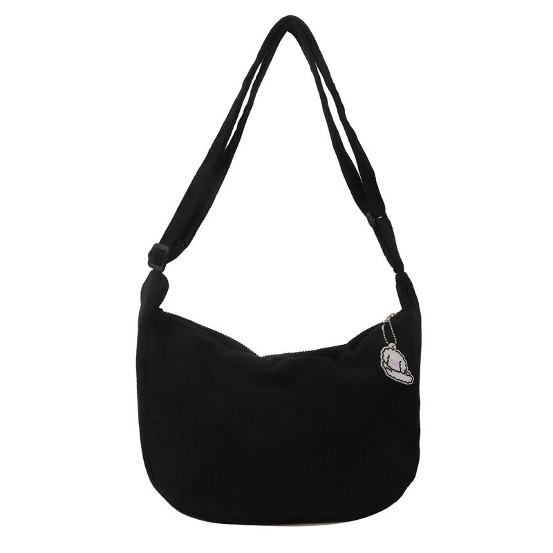 Sac à bandoulière noir en velours côtelé avec breloque argentée, design moderne et élégant, accessoire mode tendance pour femmes.