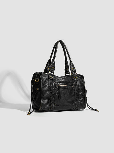 Sac à main en cuir noir élégant avec poignées doubles, détails dorés et poche zippée avant. Accessoire mode femme chic et tendance.