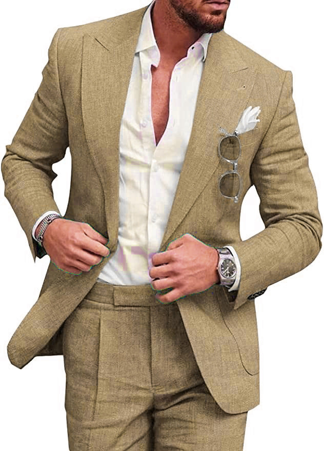Homme en costume beige élégant, chemise blanche, lunettes de soleil accrochées, montre-bracelet argentée, mouchoir blanc dans la poche.