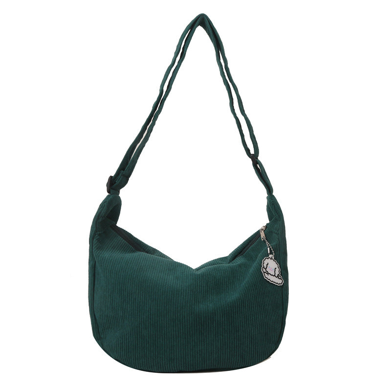 Sac à bandoulière vert en velours côtelé avec breloque, design moderne et spacieux, idéal pour un usage quotidien et tendance mode.