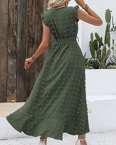 Robe longue verte à motifs floraux, manches courtes à volants, portée par une femme de dos, décor extérieur avec cactus et mur en bois.