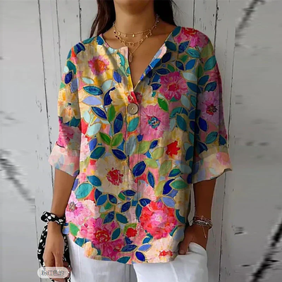 Blouse femme à manches trois-quarts, motif floral coloré, fond blanc. Mode estivale, style décontracté, tendance 2023.