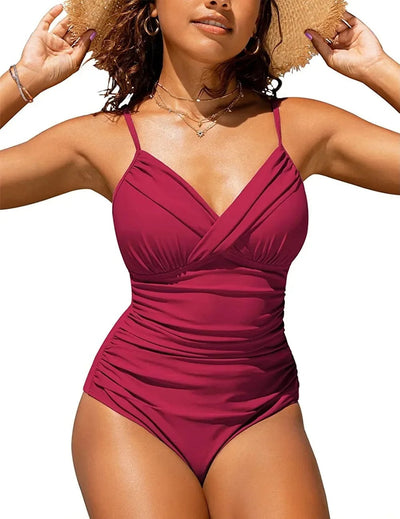 Femme en maillot de bain une pièce rouge, bretelles fines, posant en extérieur, portant un chapeau de paille, bijoux dorés, style estival.
