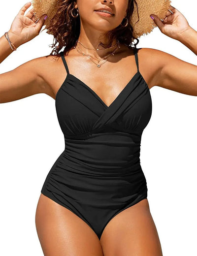 Femme portant un maillot de bain une pièce noir, bretelles fines, col en V, posant en extérieur avec un chapeau de paille. Mode plage été.