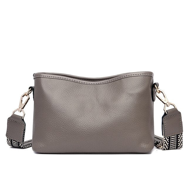 Sac à main en cuir gris avec bandoulière amovible à motifs noirs et blancs, design élégant et moderne, idéal pour la mode féminine.